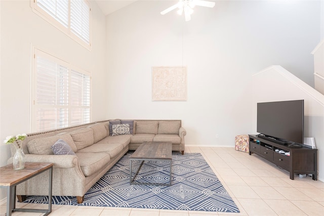 living area featuring tile patterned floors, baseboards, high vaulted ceiling, and ceiling fan