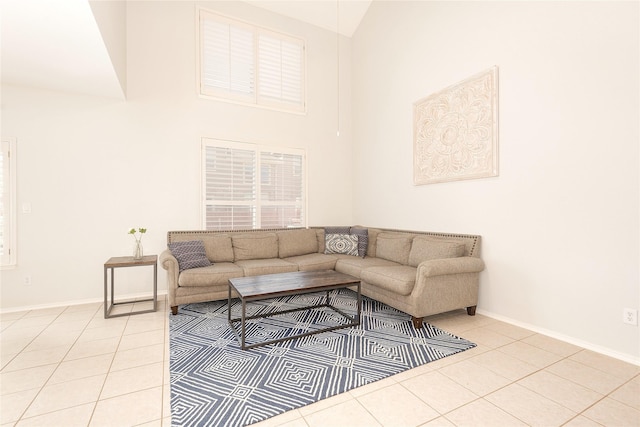 living area featuring baseboards, high vaulted ceiling, and light tile patterned floors