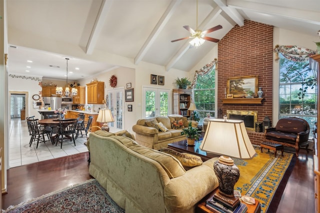 7388 Wilderness Way, Weatherford, TX 76085 - living room featuring a ceiling fan, a fireplace, beam ceiling, a chandelier, and light wood-style flooring