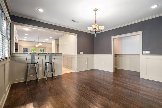422 S Winnetka Ave, Dallas, TX 75208 - dining area featuring a chandelier, wood finished floors, a decorative wall, crown molding, and a wainscoted wall