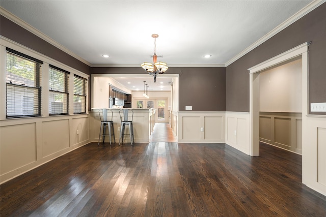 422 S Winnetka Ave, Dallas, TX 75208 - unfurnished room with a decorative wall, a chandelier, plenty of natural light, dark wood-style flooring, and crown molding