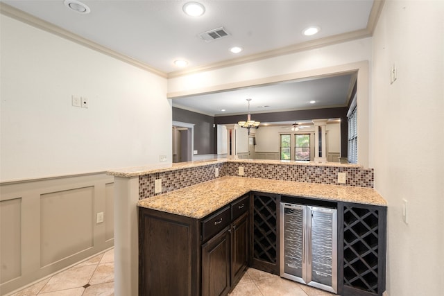 422 S Winnetka Ave, Dallas, TX 75208 - bar area with crown molding, beverage cooler, light tile patterned floors, wainscoting, and hanging light fixtures