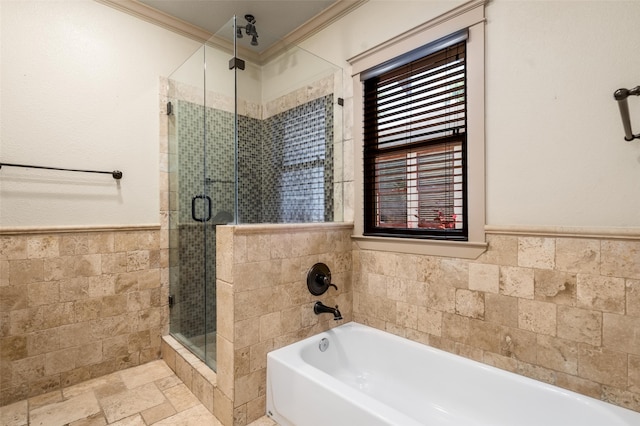 422 S Winnetka Ave, Dallas, TX 75208 - bathroom featuring tile walls, a stall shower, wainscoting, stone tile floors, and a bath