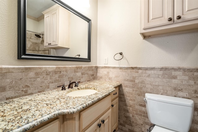 422 S Winnetka Ave, Dallas, TX 75208 - bathroom featuring tile walls, wainscoting, vanity, and toilet