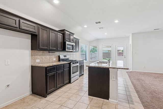 10004 Huntersville Trl, Fort Worth, TX 76108 - kitchen featuring stainless steel appliances, an island with sink, light stone countertops, backsplash, and a sink