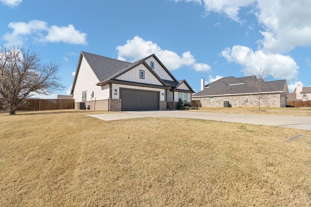 exterior space with concrete driveway, board and batten siding, fence, a yard, and brick siding