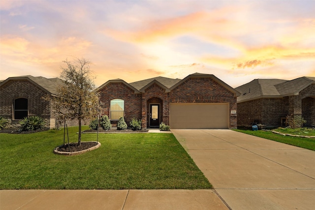 ranch-style home featuring a lawn, brick siding, a garage, and driveway
