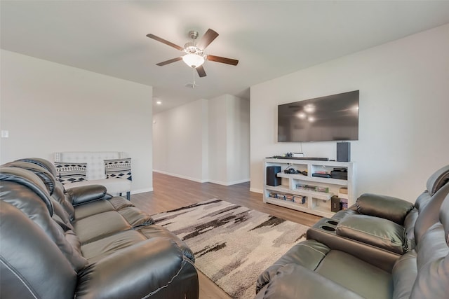 living area featuring baseboards, ceiling fan, and wood finished floors