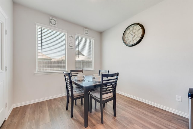 dining room featuring baseboards and light wood-type flooring