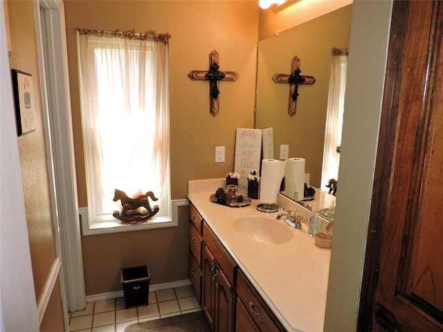 bathroom featuring baseboards, tile patterned flooring, vanity, and plenty of natural light