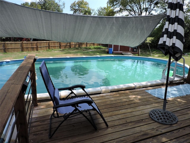 view of swimming pool with a yard, a fenced in pool, a deck, and fence