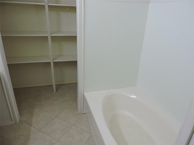 bathroom featuring tile patterned floors and a bath