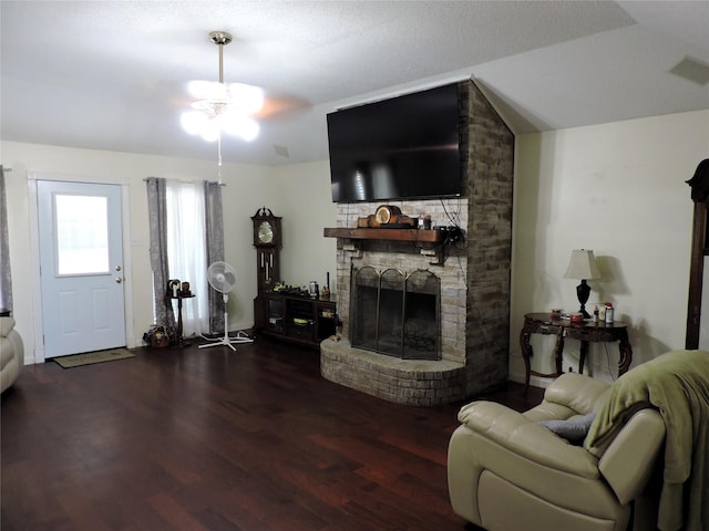 living area with a large fireplace, wood finished floors, visible vents, and ceiling fan