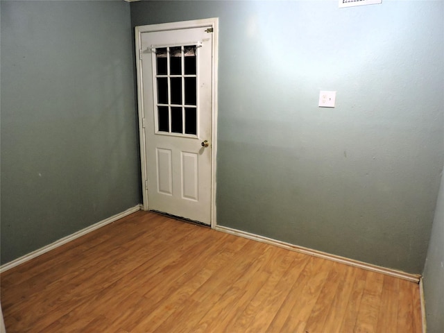 spare room featuring light wood finished floors and baseboards