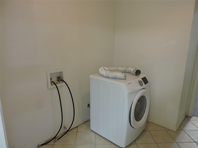 clothes washing area featuring light tile patterned flooring, washer / clothes dryer, and laundry area