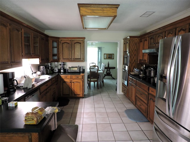kitchen featuring light tile patterned floors, ornamental molding, stainless steel appliances, dark countertops, and visible vents