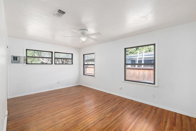 spare room featuring a ceiling fan, visible vents, light wood-type flooring, and plenty of natural light