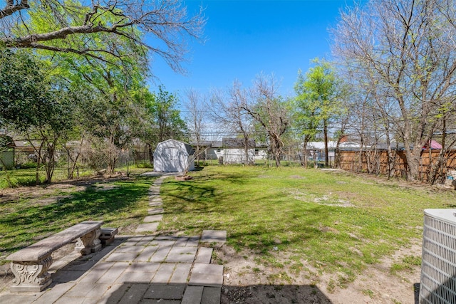 view of yard featuring cooling unit, a storage unit, a fenced backyard, and an outdoor structure