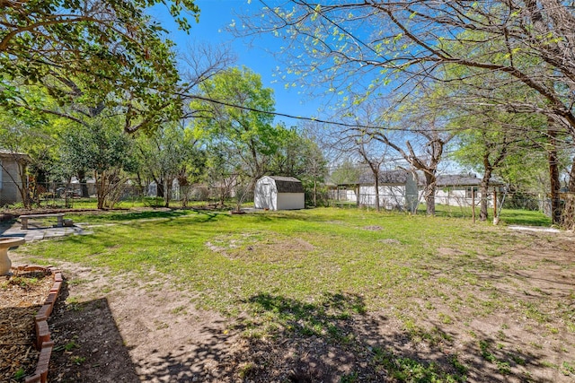 view of yard with a storage unit, a fenced backyard, and an outbuilding