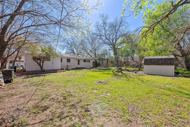 view of yard with central AC unit, an outbuilding, a storage unit, and fence