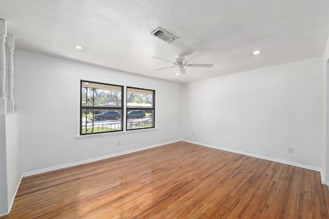 unfurnished room featuring baseboards, visible vents, light wood-style flooring, and a ceiling fan