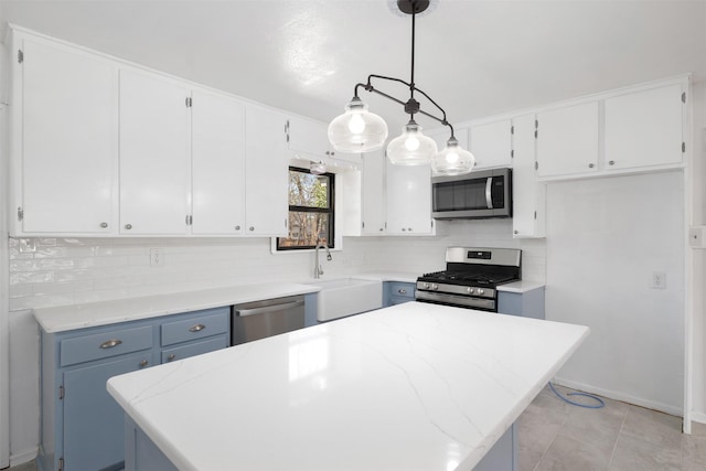 kitchen with backsplash, a sink, a center island, stainless steel appliances, and white cabinets