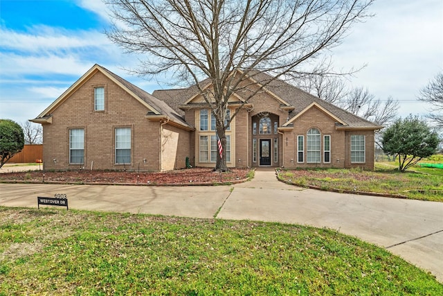 traditional home with brick siding and a front yard