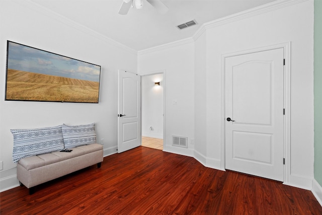 unfurnished room with visible vents, wood finished floors, ornamental molding, and a ceiling fan