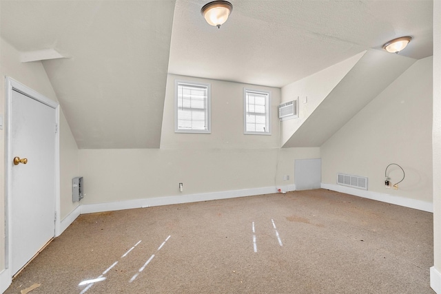 bonus room with vaulted ceiling, a textured ceiling, baseboards, visible vents, and carpet