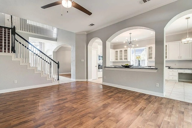 4726 Steeple Chase Ln, Rockwall, TX 75032 - unfurnished living room with a chandelier, wood finished floors, ceiling fan, crown molding, and stairway