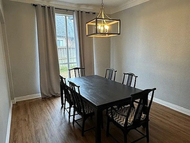 4726 Steeple Chase Ln, Rockwall, TX 75032 - dining space with dark wood finished floors, healthy amount of natural light, ornamental molding, and a textured wall