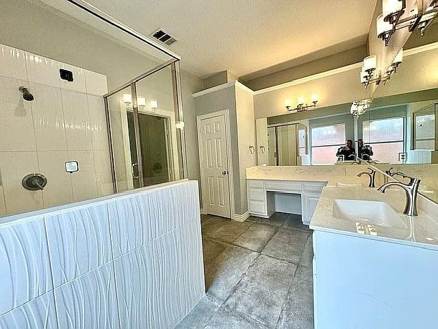 4726 Steeple Chase Ln, Rockwall, TX 75032 - full bathroom featuring walk in shower, double vanity, and a textured ceiling