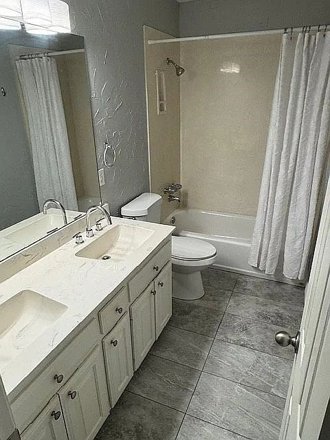 4726 Steeple Chase Ln, Rockwall, TX 75032 - bathroom featuring shower / bath combination with curtain, double vanity, a textured wall, and tile patterned floors
