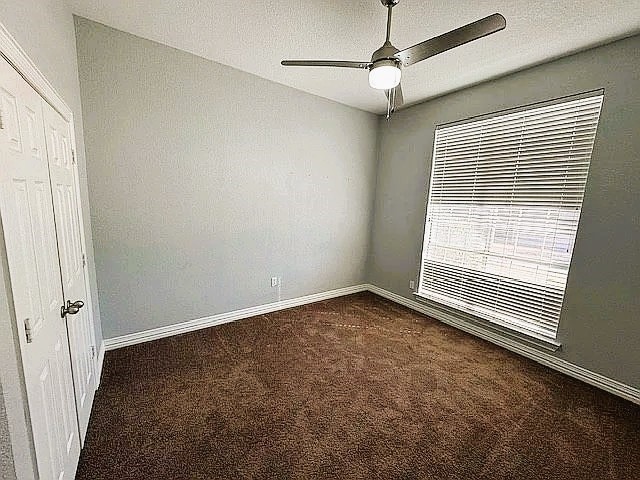 4726 Steeple Chase Ln, Rockwall, TX 75032 - spare room featuring dark colored carpet and ceiling fan