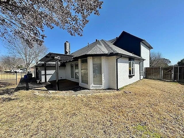 4726 Steeple Chase Ln, Rockwall, TX 75032 - view of home's exterior with a chimney, a fenced backyard, a patio, and brick siding