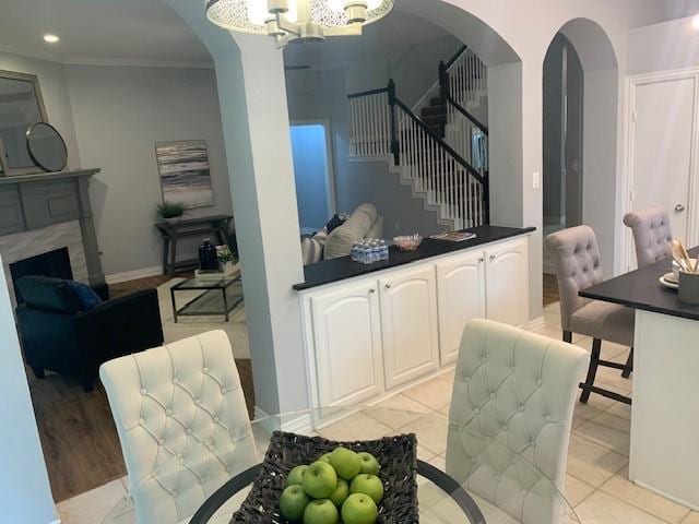 4726 Steeple Chase Ln, Rockwall, TX 75032 - dining space with arched walkways, a chandelier, stairway, ornamental molding, and a high end fireplace