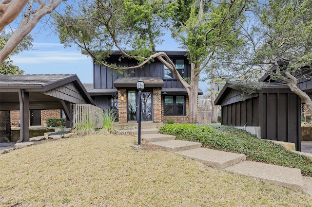 view of front of property with brick siding, board and batten siding, and a front yard