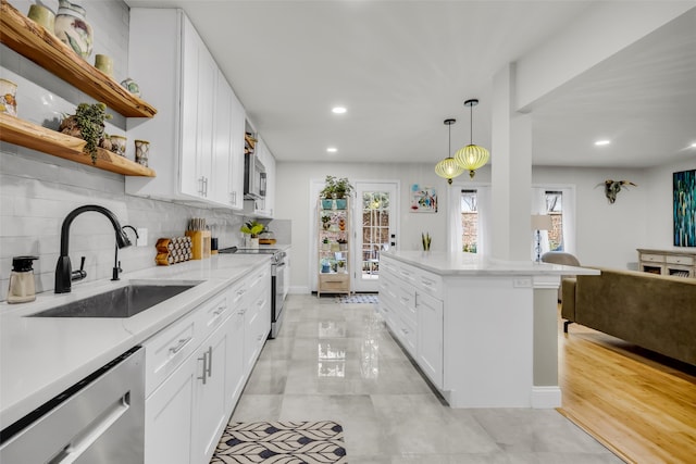 kitchen featuring a sink, open shelves, white cabinetry, tasteful backsplash, and appliances with stainless steel finishes