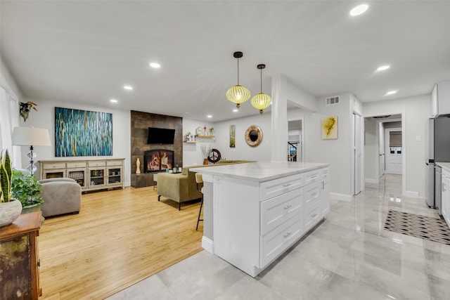kitchen featuring white cabinets, visible vents, recessed lighting, open floor plan, and freestanding refrigerator