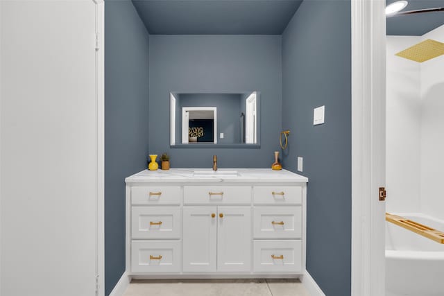 full bathroom with a tub, vanity, tile patterned floors, and baseboards