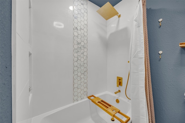full bathroom with a textured wall and shower / tub combo