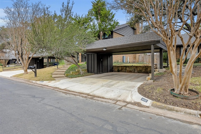 view of front of house featuring a chimney, a tiled roof, concrete driveway, and a carport