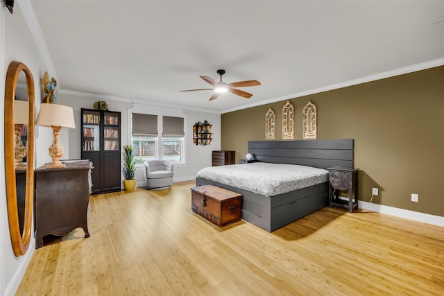 bedroom with baseboards, a ceiling fan, crown molding, and light wood finished floors