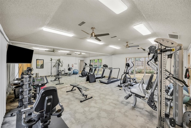 gym featuring a textured ceiling, ceiling fan, and visible vents
