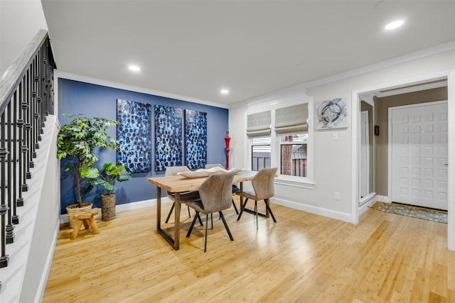 dining space with baseboards, wood finished floors, and ornamental molding