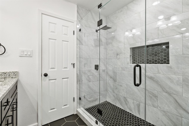 bathroom featuring tile patterned flooring, vanity, and a stall shower