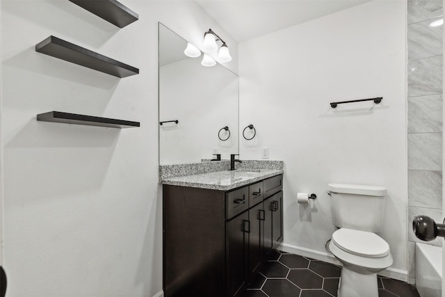 full bath featuring tile patterned flooring, vanity, toilet, baseboards, and a tub to relax in