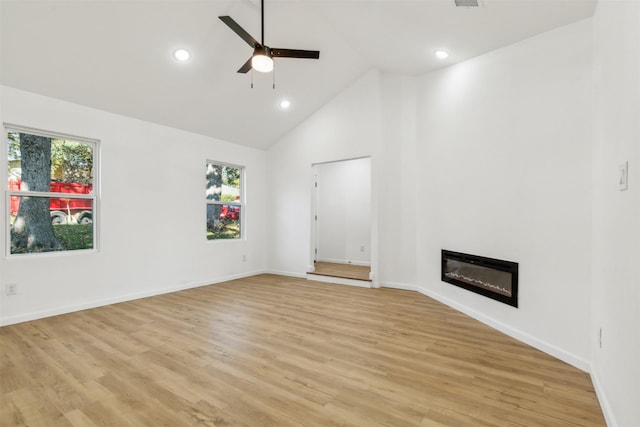 unfurnished living room featuring light wood-style flooring, high vaulted ceiling, baseboards, a ceiling fan, and a glass covered fireplace