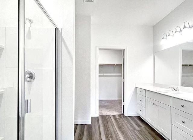 1637 Escondido Dr, Fort Worth, TX 76052 - full bathroom featuring vanity, a spacious closet, baseboards, a stall shower, and wood finished floors