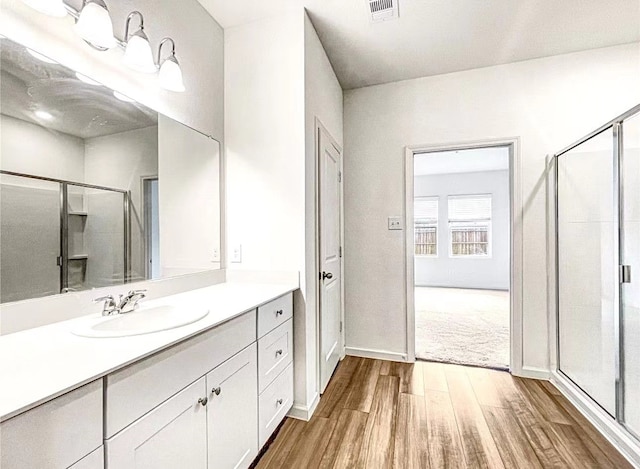 1637 Escondido Dr, Fort Worth, TX 76052 - bathroom featuring a stall shower, vanity, wood finished floors, baseboards, and visible vents